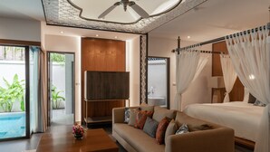 Une chambre moderne avec un lit, un canapé, une table basse et un téléviseur.