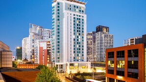 Um edifício alto com design moderno, com vários andares e uma estrutura de cobertura marcante.