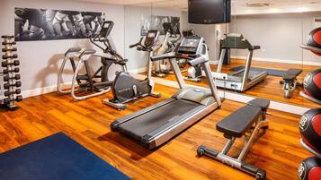 A gym with treadmills, elliptical machines, and free weights.