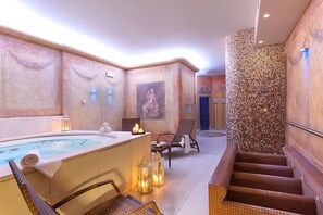 A spa area with a hot tub, seating, and a mosaic wall. - Hotel Marco Polo (Verona)