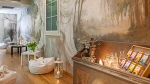 A cozy room with a rustic fireplace, a tea station, and comfortable seating. - Hotel Marco Polo (Verona)