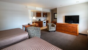A hotel room with two beds, a desk, a chair, a television, a microwave, and a kitchenette. - Canadas Best Value Inn Prince George (Prince George)