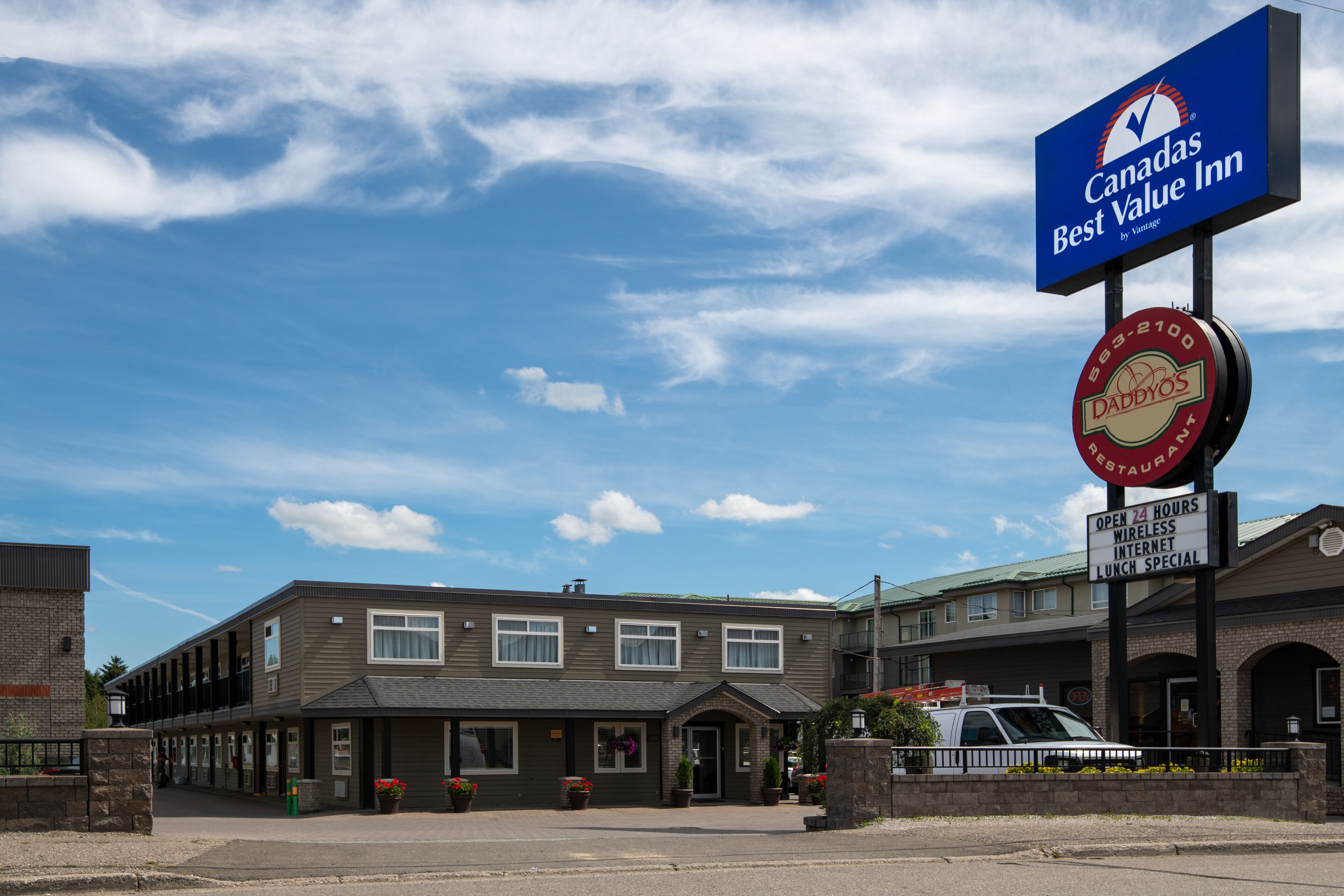 A hotel with a sign for 'Canada's Best Value Inn' and a 'Daddy's' restaurant. It has a brick facade, multiple windows, and a parking area.
