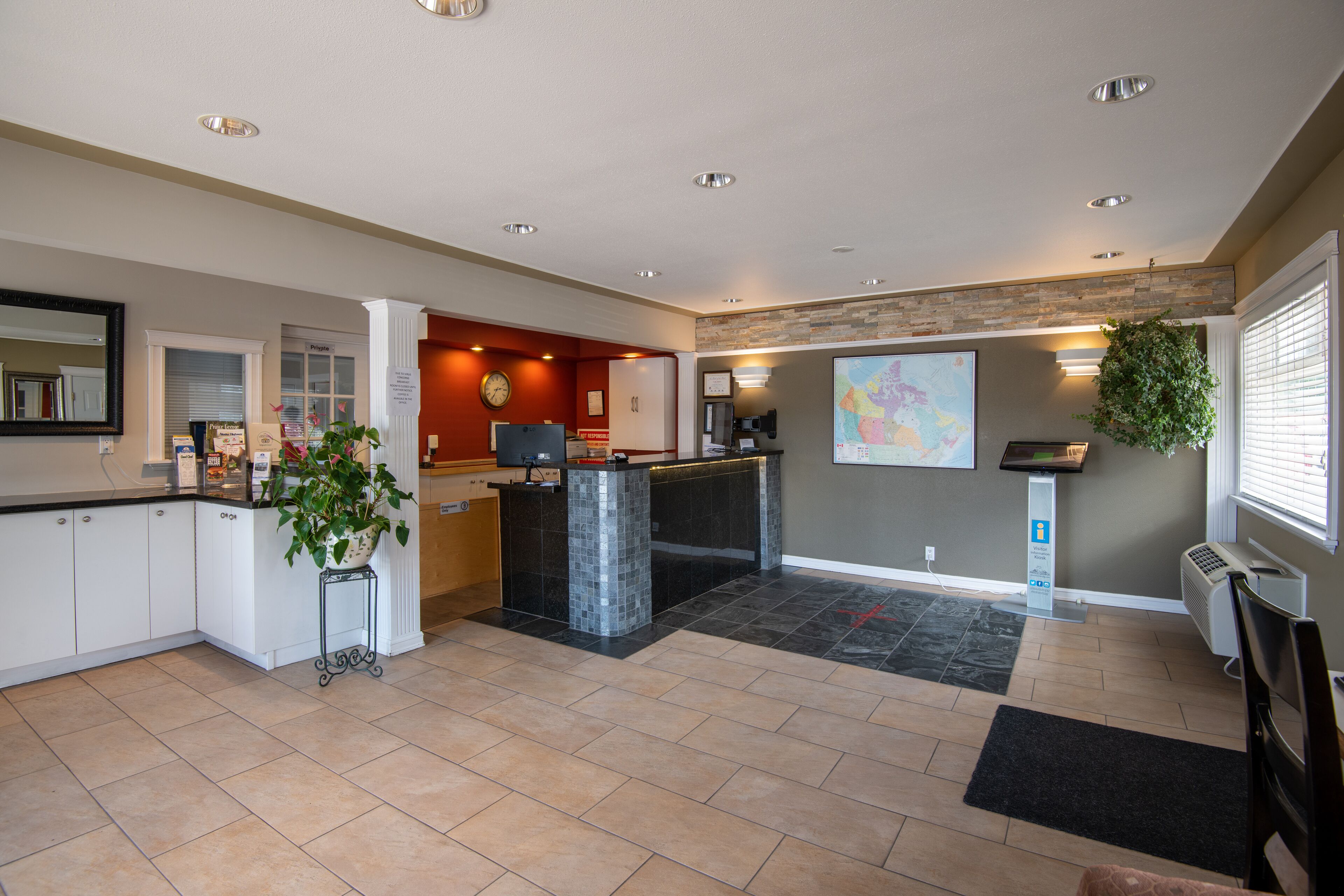 A modern reception area with a counter, a clock, and a map on the wall.