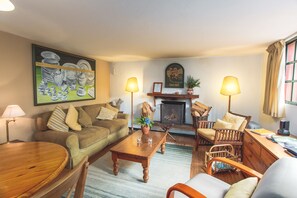 A cozy living room with a sofa, chairs, a coffee table, and a fireplace. - Valle Paraizo (Santa Cruz)