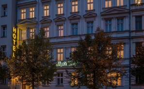 Un edificio de hotel con múltiples ventanas y un letrero de neón que dice "Myers Hotel".