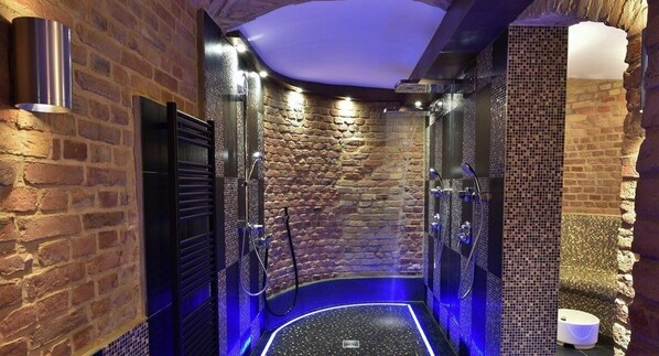Un baño moderno con pared de piedra, ducha y bañera.