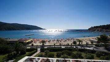 Une station balnéaire avec une plage, des bateaux et un ciel dégagé.