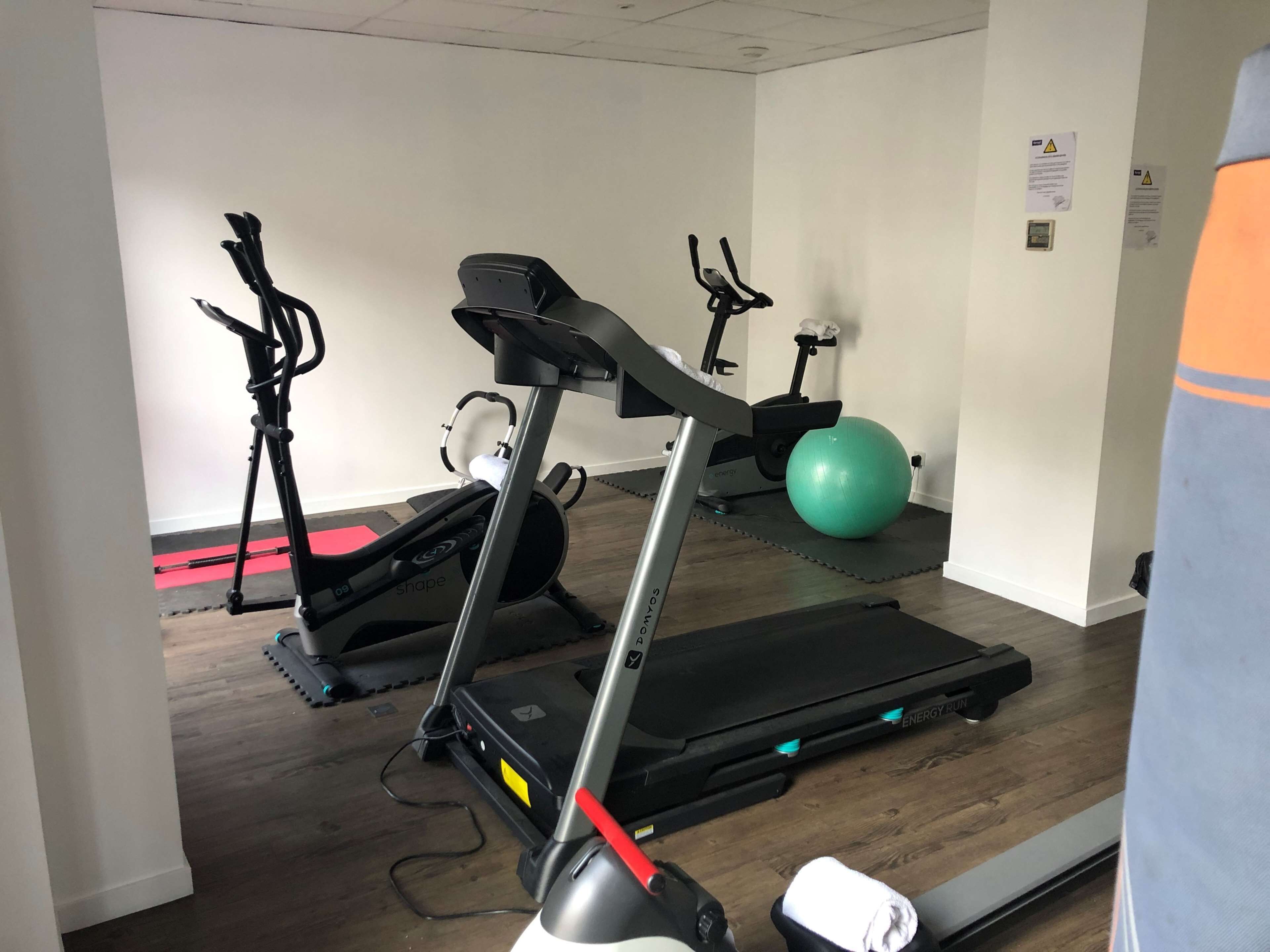 Una sala de gimnàstica amb cintes de córrer, el·líptiques i pilotes d'exercici.