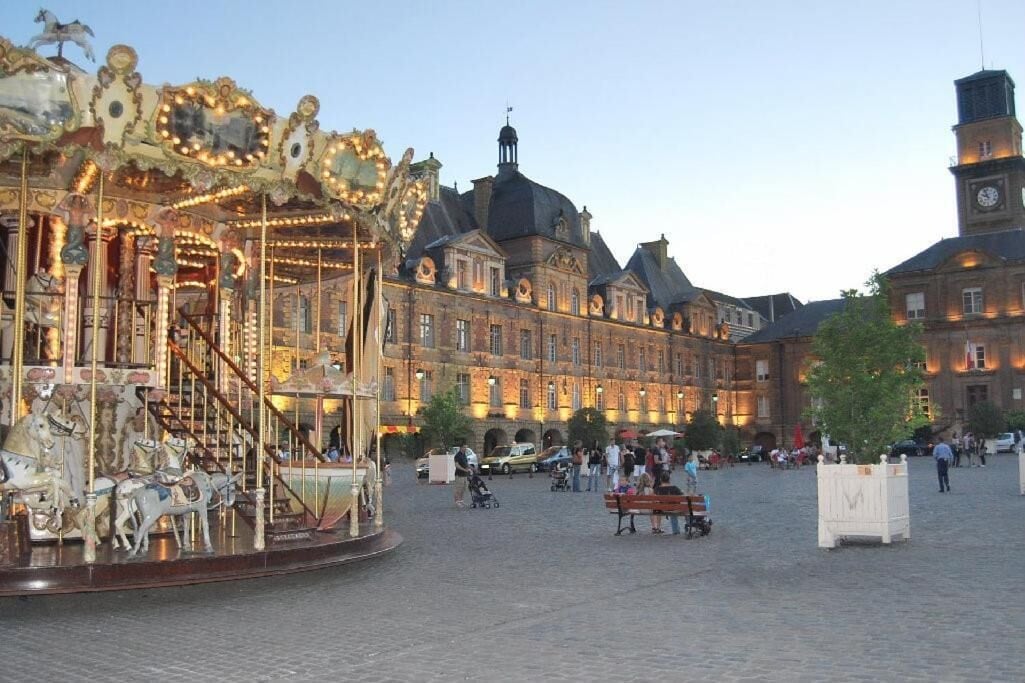 A carousel in a public square with historic buildings in the background.