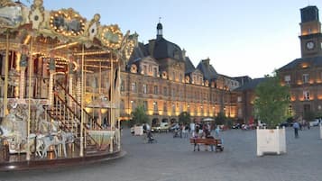 A carousel in a public square with historic buildings in the background.