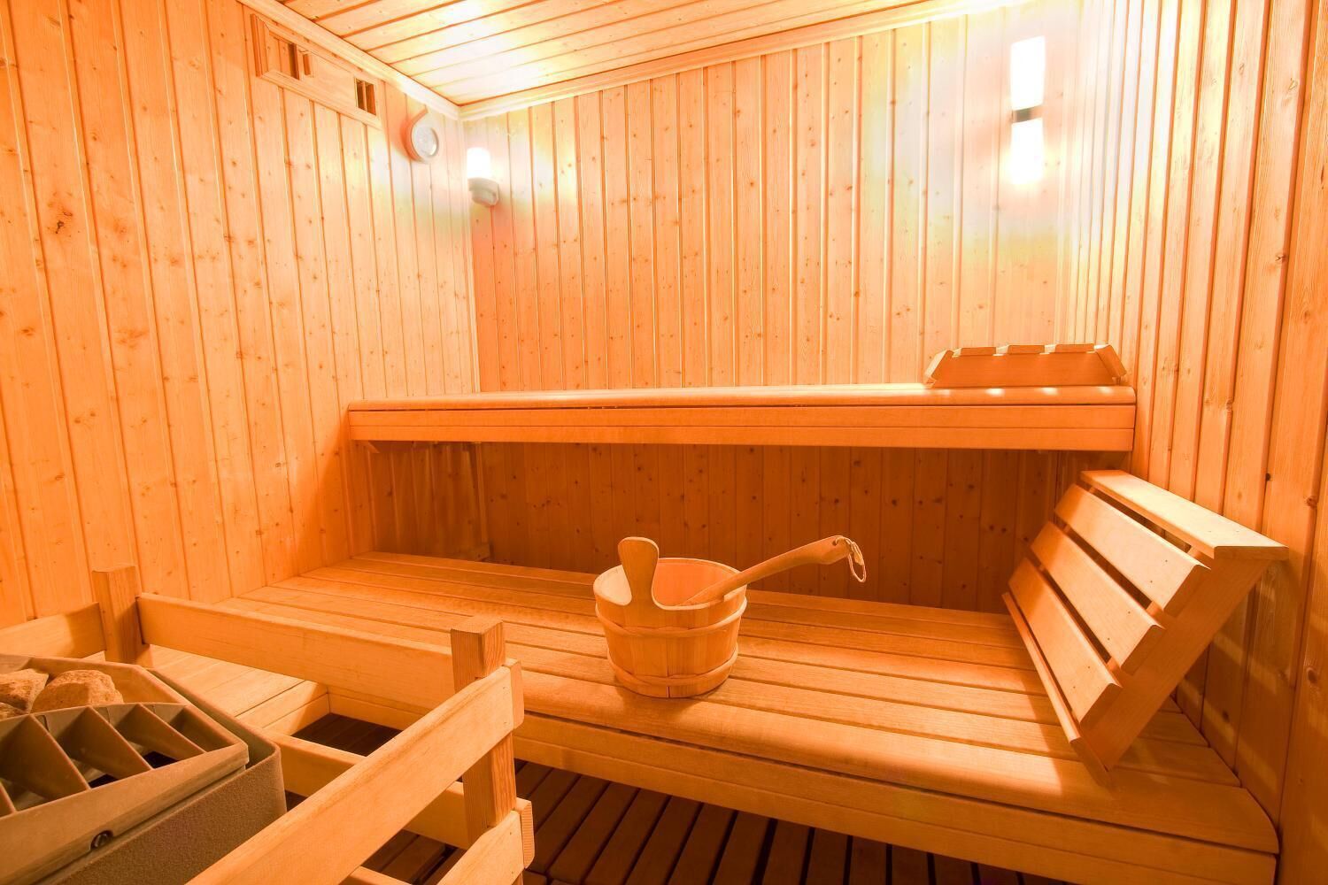 En träbeklädd bastu med sittbänkar och en hink.