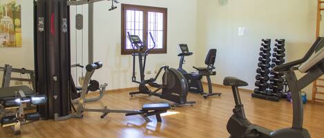 A gym with various exercise equipment, including treadmills, a stationary bike, and weight machines.