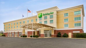 A Holiday Inn hotel with a covered entrance, multiple windows, and a flag. - Holiday Inn Florence by IHG (Florence)