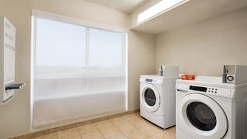 Un cuarto de lavado con lavadora, secadora y ventana con vistas.