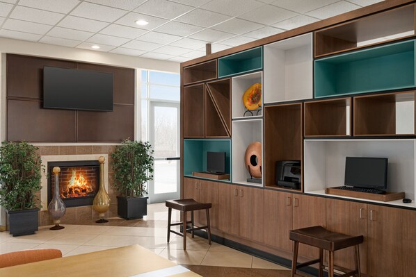 A modern living room with a fireplace, built-in shelves, and a flat-screen TV. - Holiday Inn Florence by IHG (Florence)