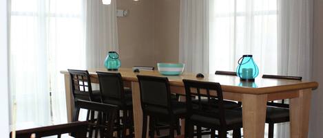 Un comedor con una mesa de madera, seis sillas y un cuenco.
