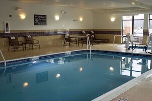 Una piscina techada, sillones reclinables de piscina