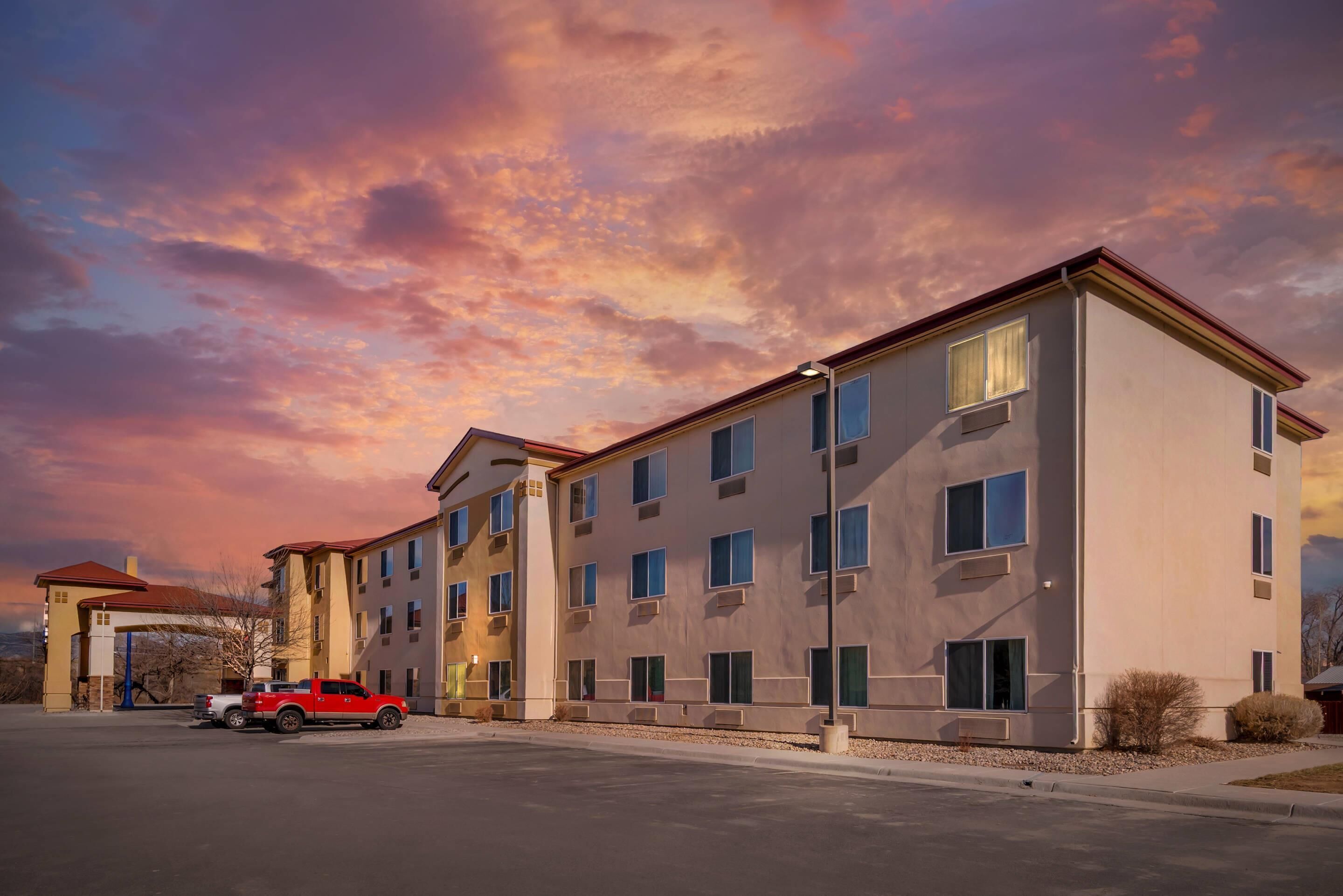A multi-story hotel with a flat roof and a parking lot.