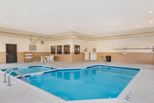Una piscina con dos carriles, una puerta, una silla y un perchero.