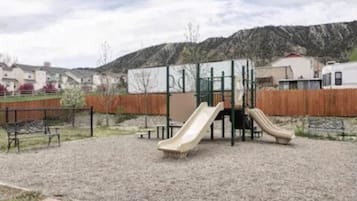 Kids can play on the playground's slides and climbing structure.