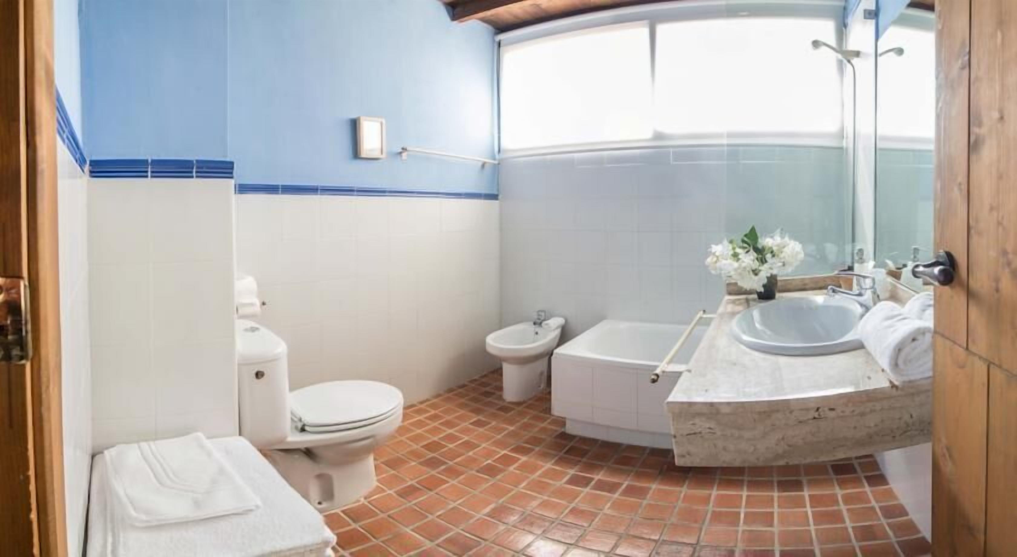 Un baño con inodoro, bidé y bañera.