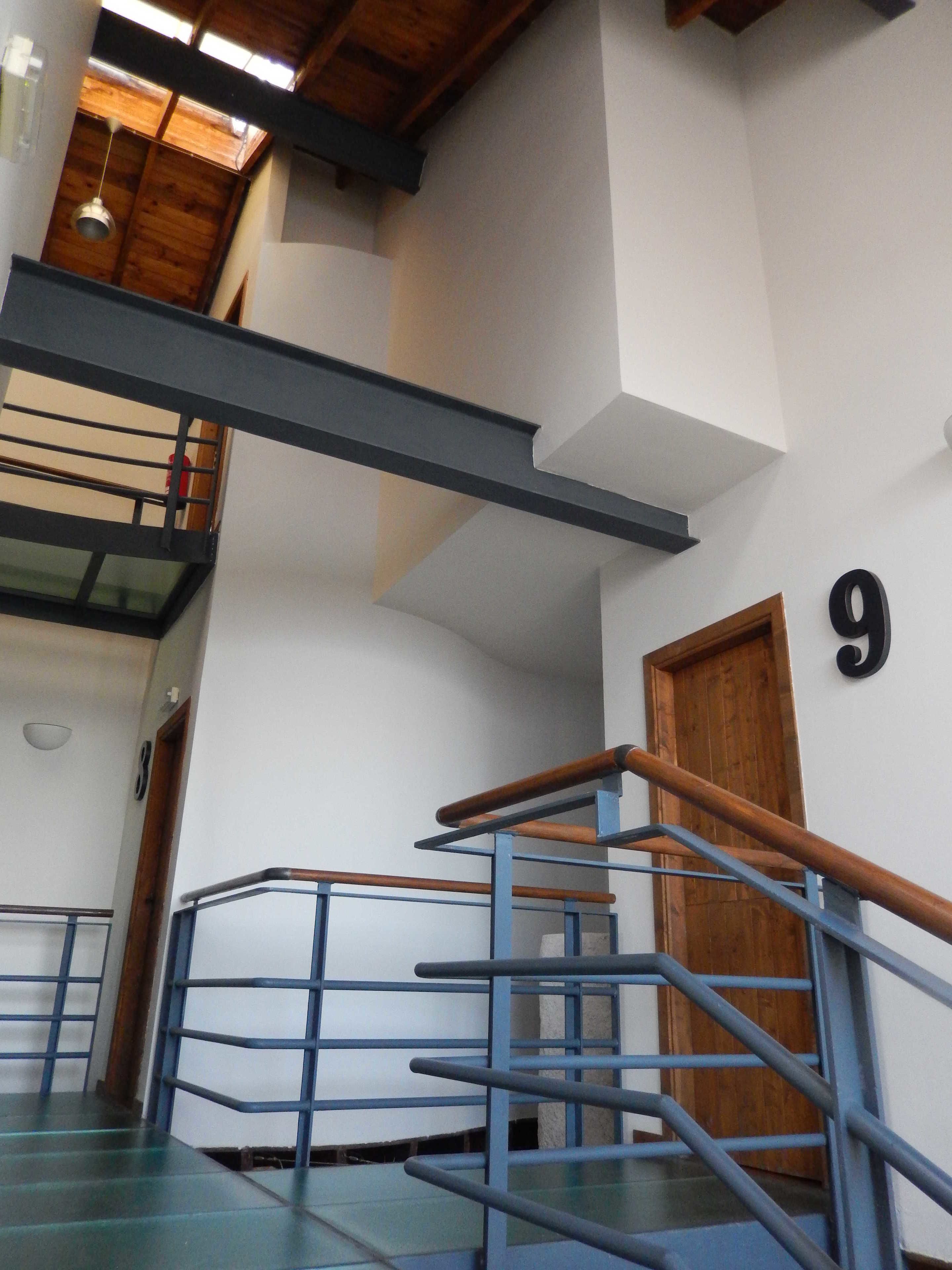 Una escalera con barandillas azules y una puerta de madera con el número 9.