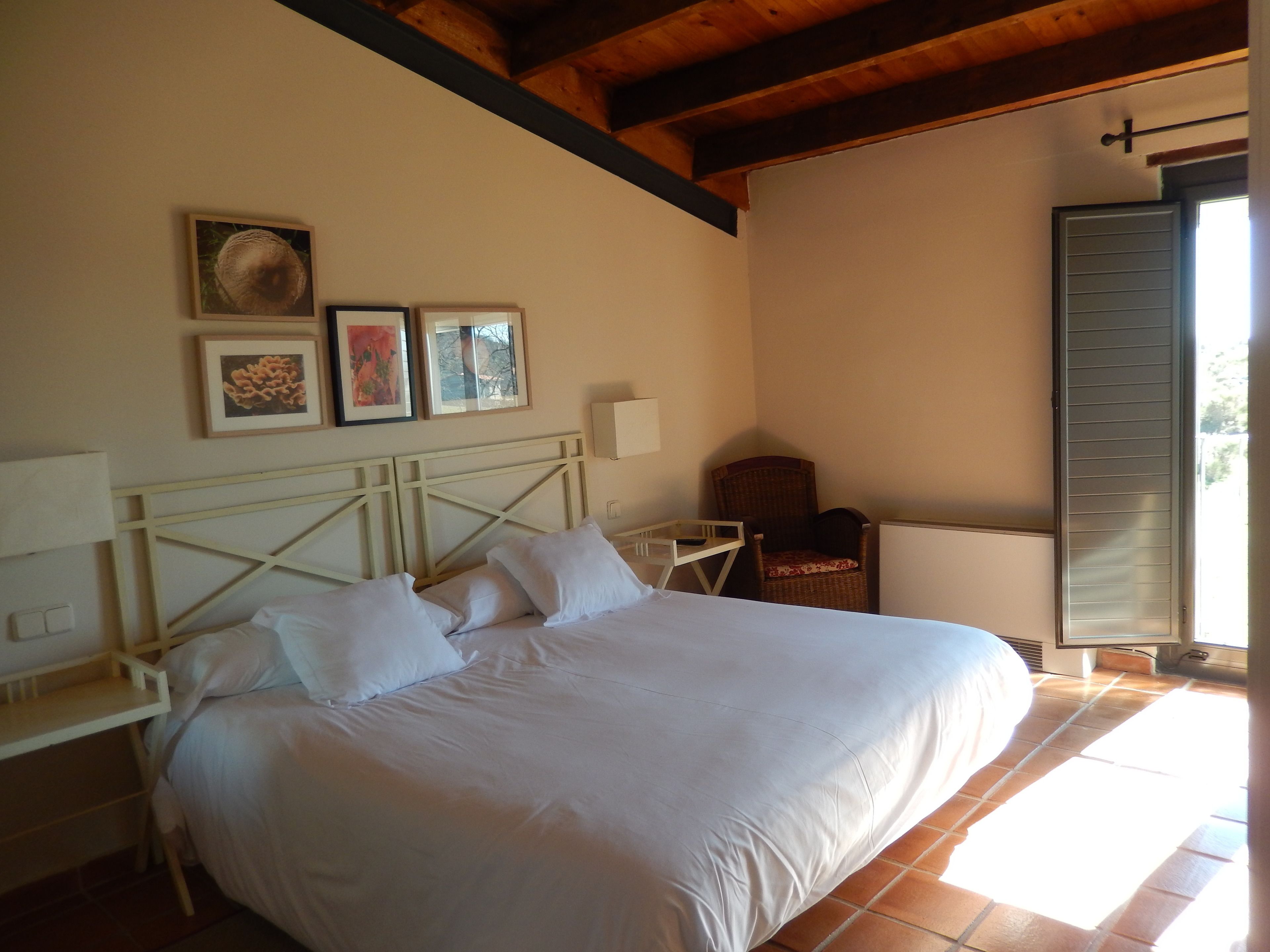 A bedroom with a bed, a chair, and a window.