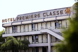 A hotel named "HOTEL PREMIERE CLASSE" with a modern architectural design, featuring a prominent balcony and a staircase leading to the entrance. - Première Classe Valence Sud (Valence)