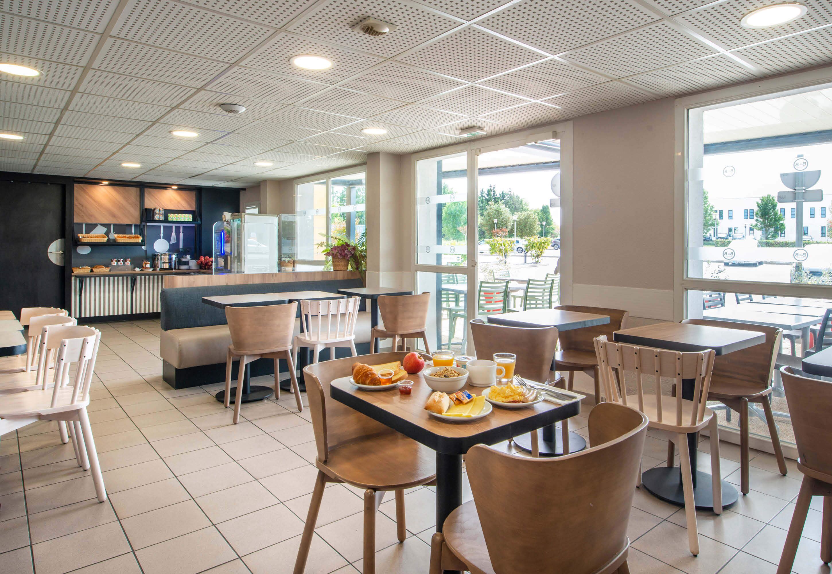 A modern cafe with a variety of seating options, including tables and chairs, and a visible counter area with a menu.