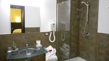 Une salle de bain moderne avec un lavabo en verre, une douche et un miroir.