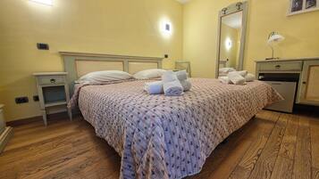 Une chambre d’hôtel comprenant un lit, des tables de chevet, un miroir, une lampe et un mini-bar.