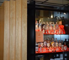 Una vitrina exhibe diversas botellas de licor, con etiquetas visibles.