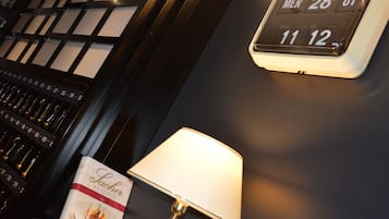 Eine digitale Uhr zeigt Datum und Uhrzeit, eine Lampe und ein Menüständer mit einem Gericht.