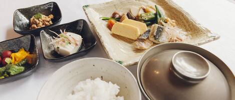 A table with various dishes including rice, tofu, and vegetables.