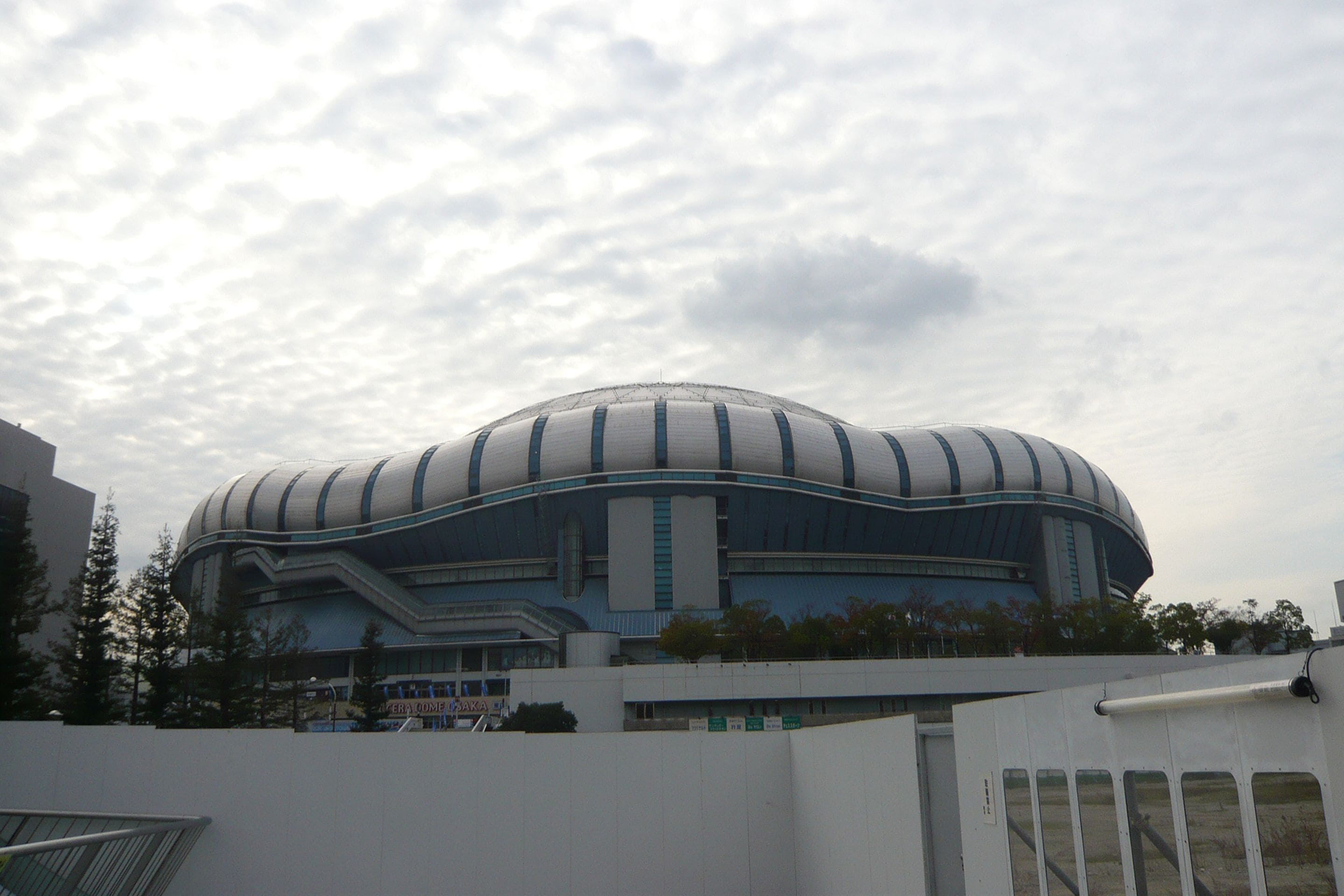 Un estadio grande y moderno con una estructura de techo curva y distintiva.