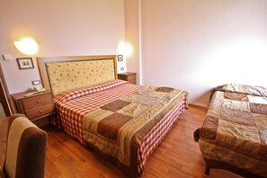 Une chambre à coucher comprenant un lit, une chaise, une table de chevet et une commode.