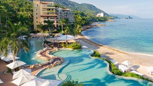 A resort with a swimming pool, beach, and ocean view.