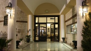 Ein Hotel mit einer Steinfassade, großen Glastüren und Pflanzkübeln.