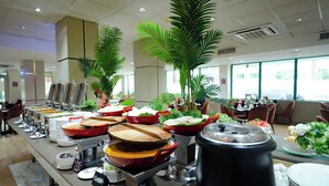 Ein Buffet mit verschiedenen Speisenstationen, darunter ein Schongarer und Salat.
