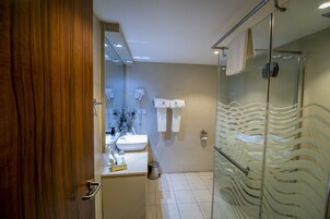 A modern bathroom with a glass shower, a sink, and a mirror.