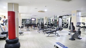 Ein Fitnessstudio mit Laufbändern, Kraftgeräten und einem roten Sandsack.