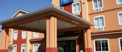 Ein Comfort Inn Hotel mit überdachter Eingangspartei, zahlreichen Fenstern und blauem Himmel.