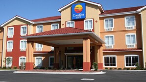 Un hotel Comfort Inn amb teulada de rajola vermella, diverses finestres i entrada coberta.
