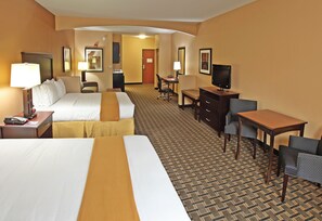 Une chambre d’hôtel avec deux lits, un bureau, une télévision et une chaise.