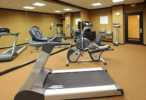 Un gimnasio equipado con cintas de correr, bicicletas estáticas y elípticas.