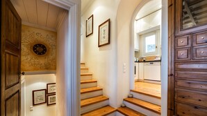 A staircase with wooden steps leading to a kitchen area. - Villa Galaxy (Mykonos)