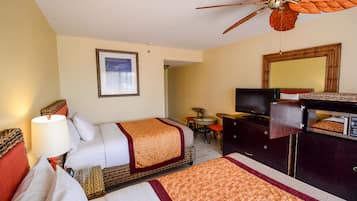 Une chambre d’hôtel avec deux lits, un ventilateur de plafond, une télévision, un bureau et un miroir.