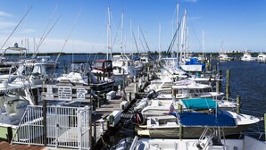 A marina with multiple boats docked, wooden walkways, and a clear blue sky. - The Royal Inn Beach Hotel Hutchinson Island (Fort Pierce)