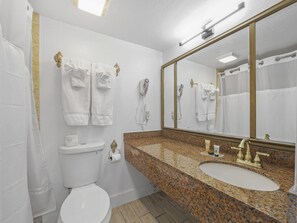 King Room Sunset View Balcony | Badkamer | Een bad/douchecombinatie, designer toiletartikelen, een haardroger